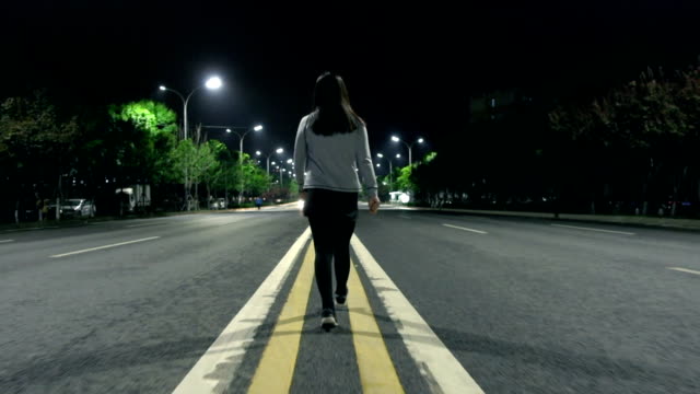 Young Woman Walking Alone On The Streets At Night