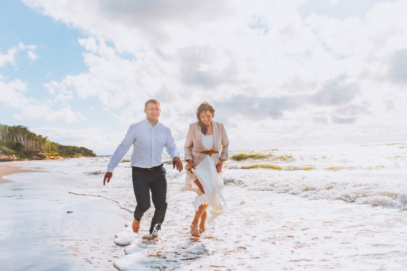 Happy,Just,Married,Middle,Age,Couple,Walk,At,Beach,Against