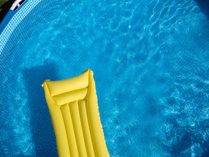 Top View Of An Inflatable Mattress In A Backyard Swimming Pool